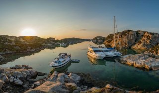 Boats and sailboat moored up in the sunset in Norway